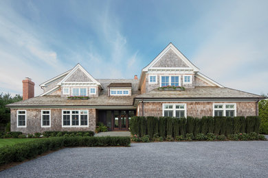 This is an example of an expansive beach style two-storey brown exterior in New York with wood siding and a gable roof.