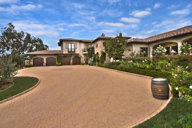 Large rustic beige two-story stucco exterior home idea in Los Angeles