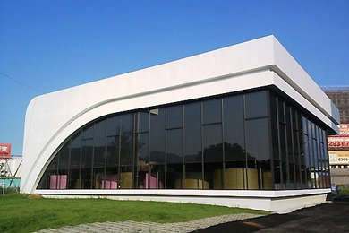 Diseño de fachada blanca contemporánea de una planta con revestimiento de vidrio, tejado plano y tejado de metal