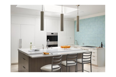 Eat-in kitchen - mid-sized contemporary l-shaped eat-in kitchen idea in Atlanta with an undermount sink, white cabinets, quartz countertops, blue backsplash, glass tile backsplash, paneled appliances, an island and white countertops