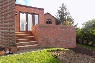 Ejemplo de fachada de casa tradicional pequeña de una planta con revestimiento de ladrillo y tejado plano