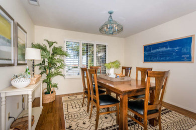 Photo of a beach style separate dining room in San Luis Obispo with white walls, medium hardwood floors and no fireplace.