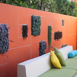 Design ideas for a mid-sized modern backyard full sun formal garden for summer in Los Angeles with a vertical garden and natural stone pavers.