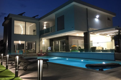 Foto di una piscina monocorsia design rettangolare di medie dimensioni e dietro casa con piastrelle