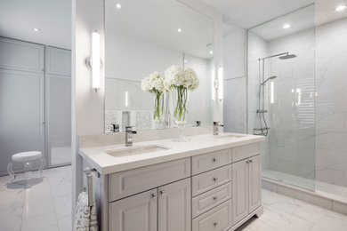 Large trendy master white tile and porcelain tile porcelain tile doorless shower photo in Toronto with furniture-like cabinets, gray cabinets, a one-piece toilet, white walls, an undermount sink and quartz countertops