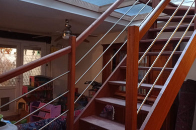 Réalisation d'un escalier courbe design de taille moyenne avec des marches en bois et un garde-corps en bois.