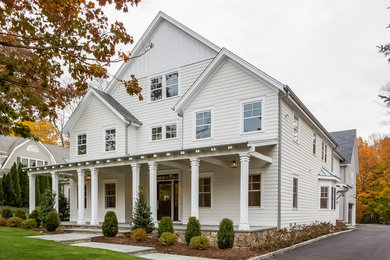 Large elegant white two-story wood exterior home photo in New York with a shingle roof