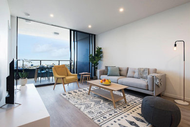 This is an example of a contemporary living room in Brisbane with white walls and vinyl floors.