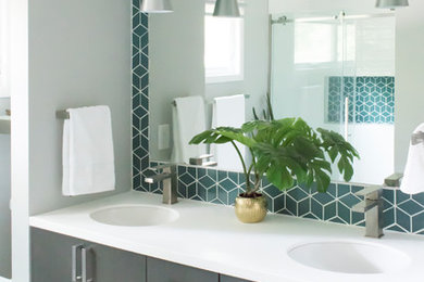 Photo of a mid-sized midcentury master bathroom in Chicago with flat-panel cabinets, dark wood cabinets, grey walls, an undermount sink, solid surface benchtops, white floor, white benchtops, an alcove shower, a two-piece toilet, green tile, ceramic tile, mosaic tile floors and a sliding shower screen.