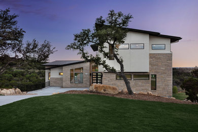 Large trendy brown three-story stucco house exterior photo in Austin with a shed roof, a metal roof and a black roof
