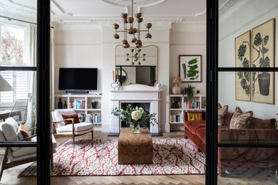 This is an example of a traditional living room in London with white walls and a wall mounted tv.