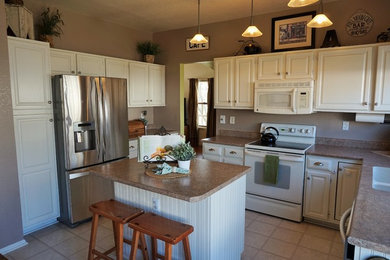 Inspiration for a mid-sized timeless l-shaped ceramic tile and beige floor enclosed kitchen remodel in Denver with a double-bowl sink, raised-panel cabinets, white cabinets, granite countertops, stainless steel appliances and an island