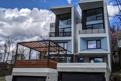 Example of a huge multicolored three-story board and batten exterior home design in Other