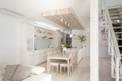 Foto di una cucina nordica con lavello sottopiano, ante a filo, ante bianche, top in superficie solida, paraspruzzi bianco, penisola, top bianco e pavimento beige