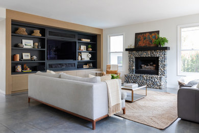 Example of an arts and crafts open concept gray floor living room design in San Diego with a standard fireplace, a stone fireplace and a media wall
