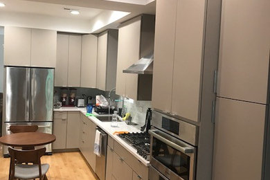 Eat-in kitchen - modern l-shaped light wood floor eat-in kitchen idea in Chicago with a single-bowl sink, flat-panel cabinets, gray cabinets, quartzite countertops, white backsplash, glass tile backsplash and stainless steel appliances
