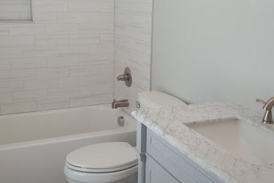 Modernes Badezimmer mit freistehender Badewanne, grauen Fliesen, Keramikfliesen, grauer Wandfarbe, Porzellan-Bodenfliesen, Marmor-Waschbecken/Waschtisch, grauem Boden und grauer Waschtischplatte in Raleigh