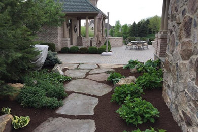 This is an example of a large traditional full sun backyard stone landscaping in Other for summer.