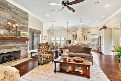 Living room - large transitional formal and open concept medium tone wood floor and brown floor living room idea in New Orleans with beige walls, a standard fireplace, a stone fireplace and no tv