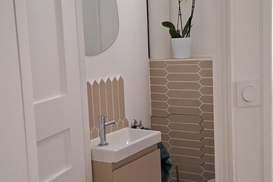 Aménagement d'un petit WC suspendu contemporain avec un placard à porte plane, des portes de placard beiges, un carrelage beige, des carreaux de céramique, un mur blanc, un sol en carrelage de céramique, un lavabo suspendu, un plan de toilette en carrelage, un sol gris, un plan de toilette blanc et meuble-lavabo suspendu.