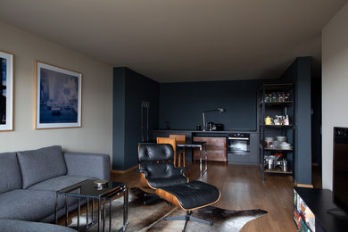 Mittelgroßes, Offenes Modernes Wohnzimmer mit beiger Wandfarbe, hellem Holzboden und freistehendem TV in Berlin