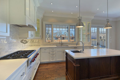 Inspiration for a large traditional l-shaped open plan kitchen in Toronto with an undermount sink, shaker cabinets, white cabinets, quartz benchtops, stone tile splashback, stainless steel appliances, dark hardwood floors, with island and grey splashback.