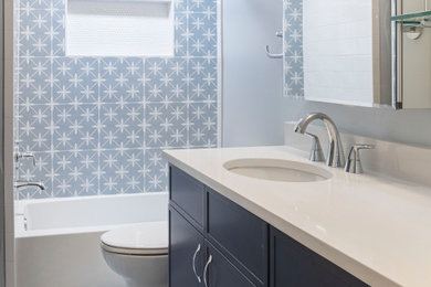 ワシントンD.C.にある高級な中くらいなミッドセンチュリースタイルのおしゃれな浴室 (家具調キャビネット、青いキャビネット、アルコーブ型浴槽、アルコーブ型シャワー、分離型トイレ、青いタイル、磁器タイル、青い壁、磁器タイルの床、アンダーカウンター洗面器、クオーツストーンの洗面台、青い床、オープンシャワー、白い洗面カウンター、ニッチ、洗面台1つ、造り付け洗面台) の写真