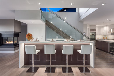 Photo of a large contemporary seated home bar in Vancouver with quartzite benchtops, white splashback, porcelain floors and white benchtop.