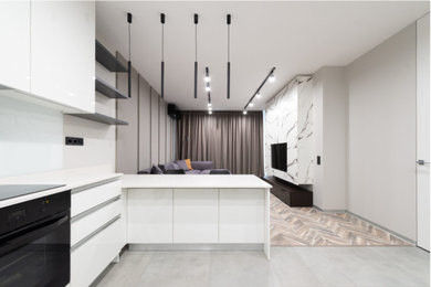 Example of a small minimalist gray floor kitchen design in DC Metro with white cabinets, white backsplash and white countertops