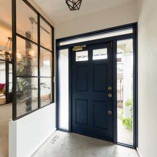 他の地域の片開きドアエクレクティックスタイルのおしゃれな玄関 (白い壁、コンクリートの床、黒いドア、グレーの床) の写真