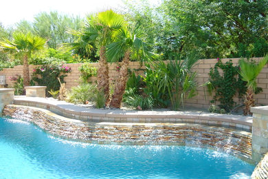 Example of a large island style backyard custom-shaped natural pool design in Los Angeles with decking