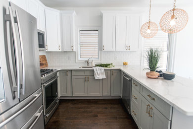 Open concept kitchen - large transitional u-shaped dark wood floor and brown floor open concept kitchen idea in New York with an undermount sink, shaker cabinets, white cabinets, quartz countertops, white backsplash, porcelain backsplash, stainless steel appliances and a peninsula