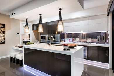 This is an example of a contemporary galley kitchen in Canberra - Queanbeyan with an undermount sink, flat-panel cabinets, black cabinets, window splashback, stainless steel appliances, with island, grey floor and white benchtop.