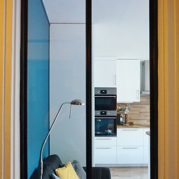Une cuisine ouverte sur une salle à manger, toute de blanc et de bleu