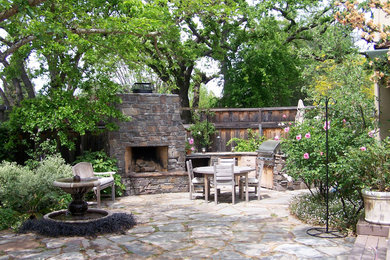 Design ideas for a mid-sized arts and crafts backyard patio in San Francisco with a fire feature, natural stone pavers and no cover.