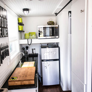 Diseño de cocina de galera, ecléctica, cerrada, con puertas de armario blancas y electrodomésticos de acero inoxidable