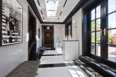 This is an example of a mid-sized contemporary foyer in New York with white walls, marble floors, a double front door and a black front door.