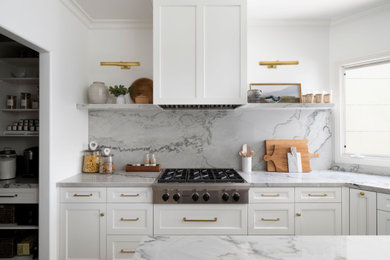 Inspiration for a large transitional u-shaped separate kitchen in San Diego with an undermount sink, beaded inset cabinets, white cabinets, quartzite benchtops, grey splashback, stone slab splashback, panelled appliances, limestone floors, with island, beige floor and grey benchtop.