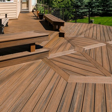 Round Trex deck with inlay, built in benches, and cable rail framed in aluminum