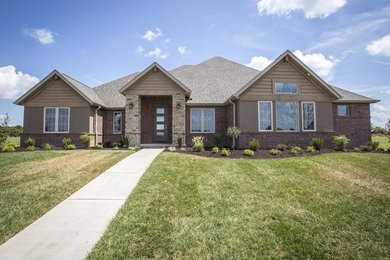 Mid-sized elegant beige one-story brick house exterior photo in Other with a hip roof and a shingle roof