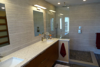 This is an example of a mid-sized contemporary master bathroom in Tampa with flat-panel cabinets, medium wood cabinets, an open shower, porcelain tile, porcelain floors, an undermount sink, engineered quartz benchtops, a one-piece toilet, gray tile, white tile and yellow walls.