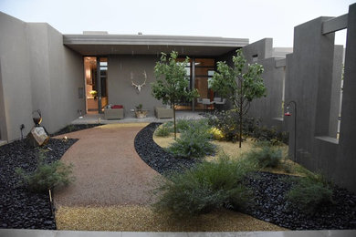 Design ideas for a mid-sized contemporary courtyard partial sun xeriscape in Albuquerque with a water feature and natural stone pavers.