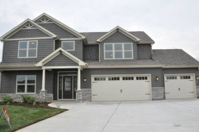 Example of a huge classic gray two-story wood gable roof design in Other