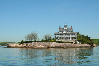 Example of a huge classic beige three-story exterior home design in New York with a shingle roof