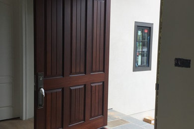 Photo of a large contemporary front door in Other with a pivot front door and a medium wood front door.