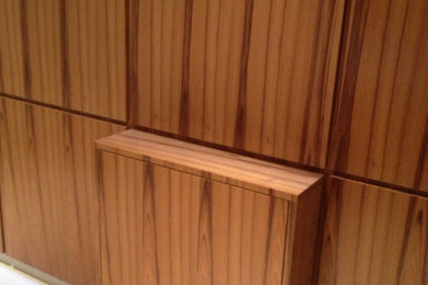 Foto de armario y vestidor nórdico pequeño con a medida, armarios con paneles lisos y puertas de armario de madera oscura