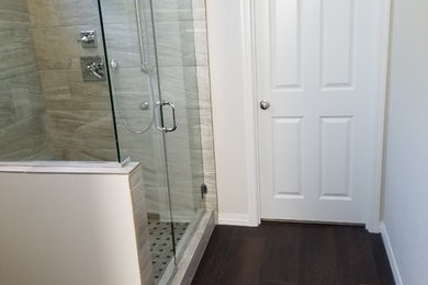 Inspiration for a mid-sized contemporary master bathroom in Portland with shaker cabinets, white cabinets, gray tile, porcelain tile, vinyl floors, an undermount sink, engineered quartz benchtops, brown floor, multi-coloured benchtops, an alcove shower, beige walls and a hinged shower door.