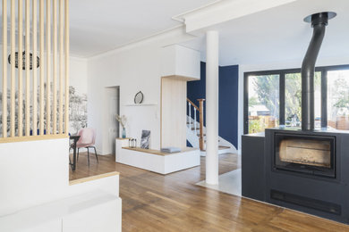 Inspiration for a mid-sized contemporary open concept light wood floor living room remodel in Nantes with a wood stove