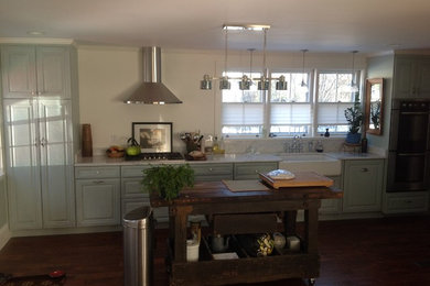 Example of a mid-sized country single-wall dark wood floor open concept kitchen design in Boston with a farmhouse sink, raised-panel cabinets, beige cabinets, marble countertops, stone slab backsplash, stainless steel appliances, an island and white backsplash