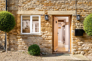 Photo of a large country two-storey brown house exterior in Gloucestershire with stone veneer.